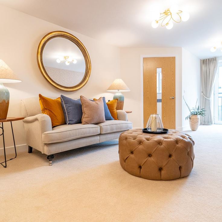 a living room with a couch and a round mirror