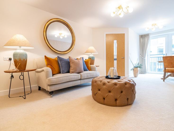 a living room with a couch and a round mirror