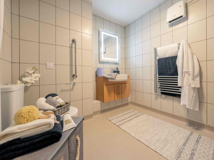 a bathroom with a tub toilet and towels