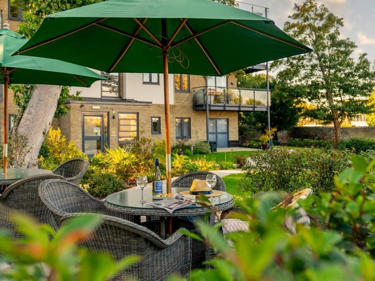a patio with a table and chairs and umbrellas