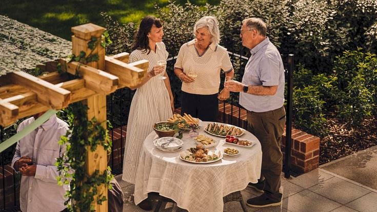 a group of people standing around a table with food on it