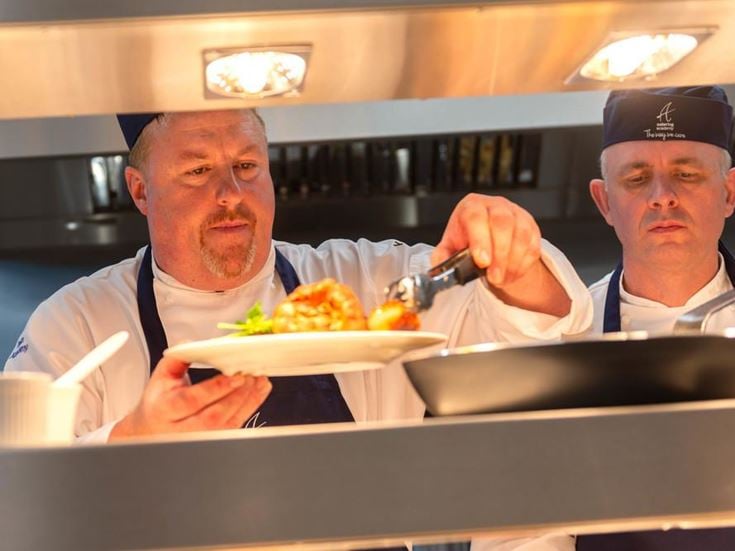 a couple of men holding a plate of food