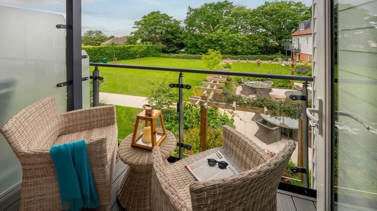 a deck with a table and chairs and a view of a golf course