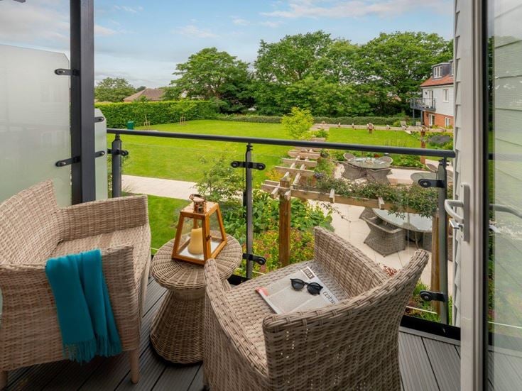 a deck with a table and chairs and a view of a golf course