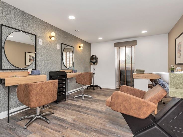 a room with a desk and chairs