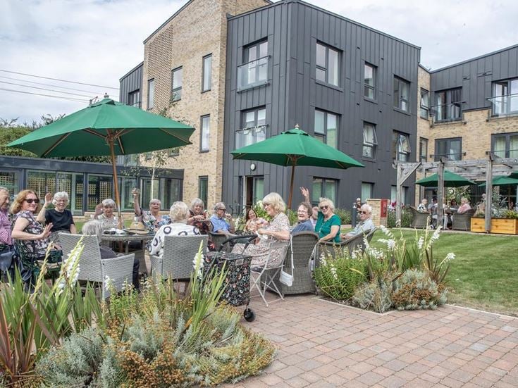 a group of people sitting at a table outside