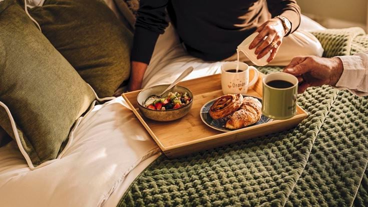 a person eating food on a bed