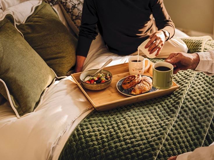 a person eating food on a bed