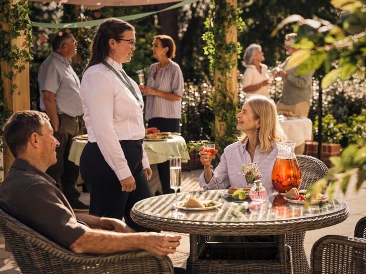 a group of people standing around a table with food on it