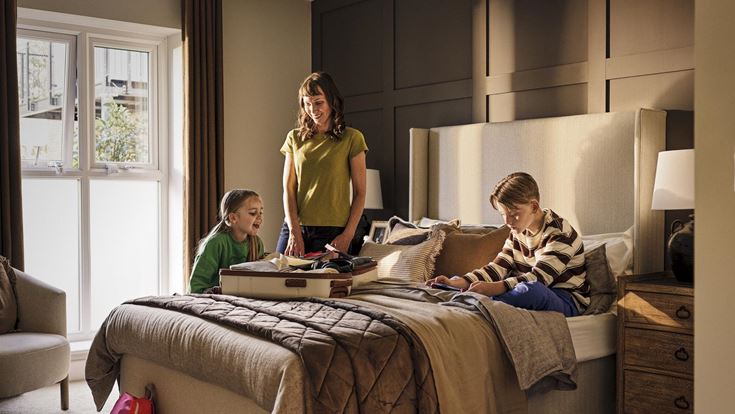a person and a couple of kids on a bed