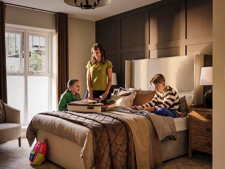 a person and a couple of kids on a bed