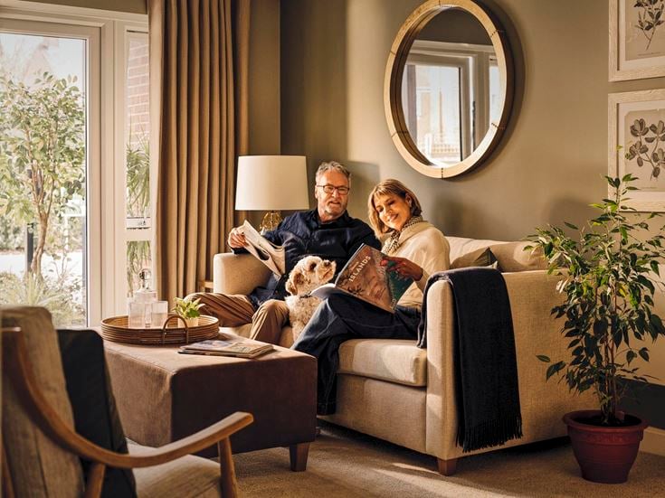 a man and woman sitting on a couch with a dog