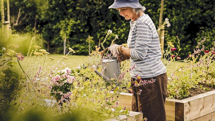 a man holding a bucket of flowers
