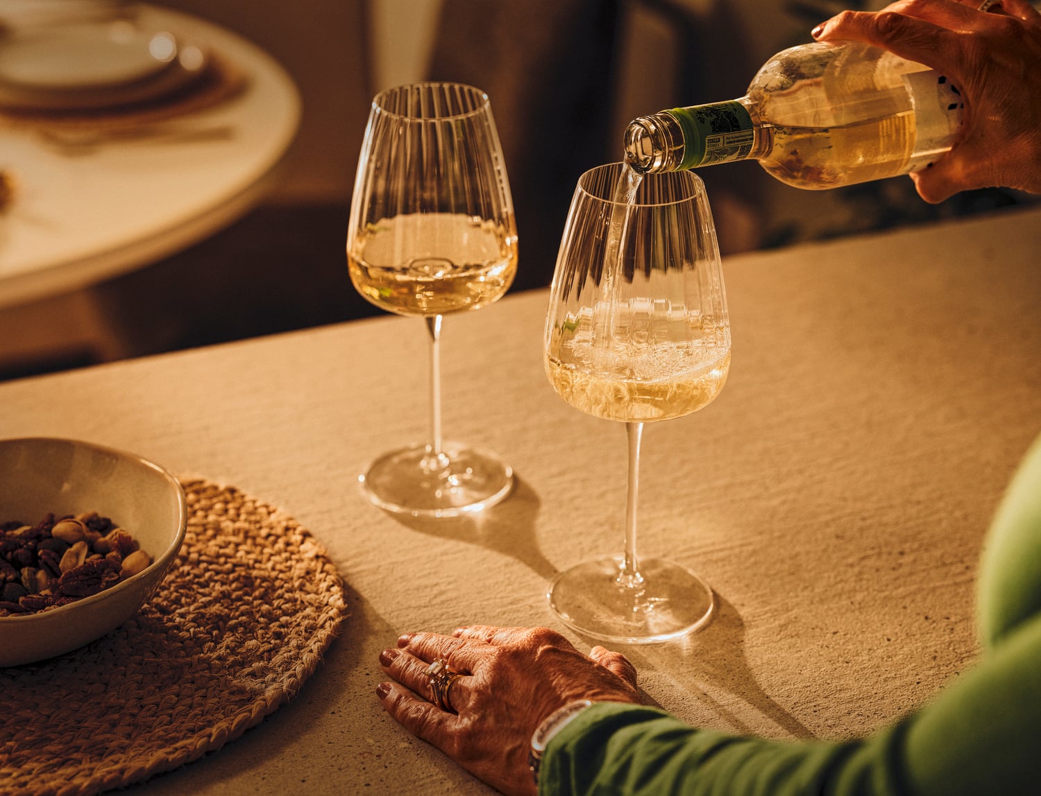 a person pouring a glass of wine