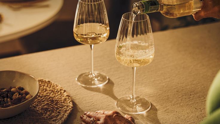 a person pouring a glass of wine