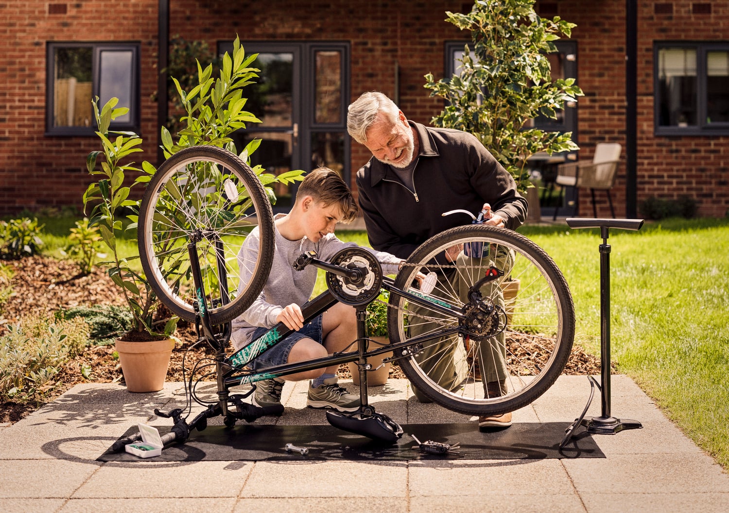 a man and a boy sitting on a bench with their bikes
