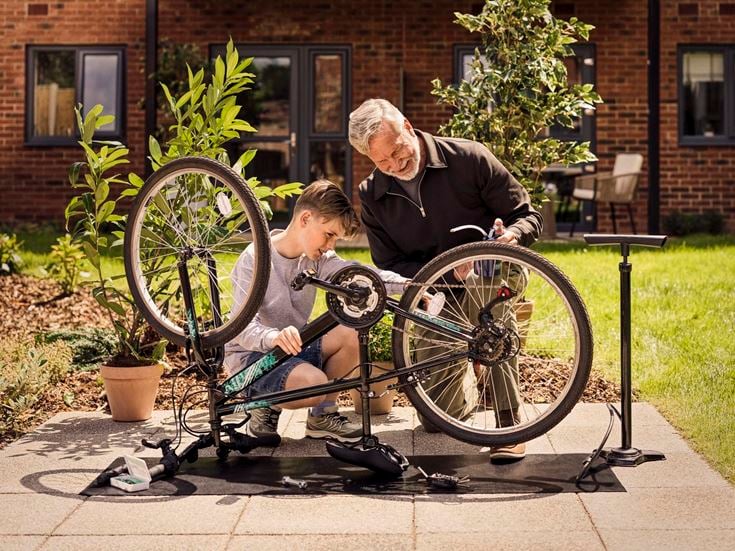 a man and a boy sitting on a bench with their bikes