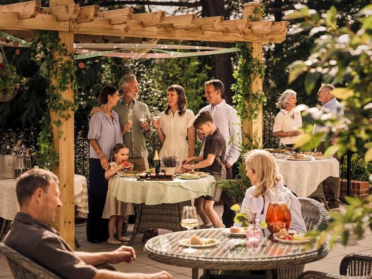 a group of people standing around a table with food on it