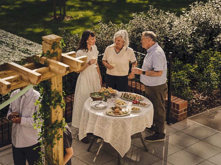 a group of people standing around a table with food on it