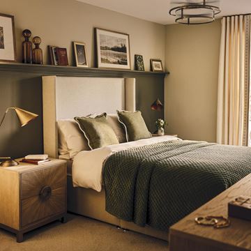 a bedroom with a bed and a shelf with pictures on it