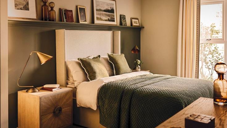 a bedroom with a bed and a shelf with pictures on it