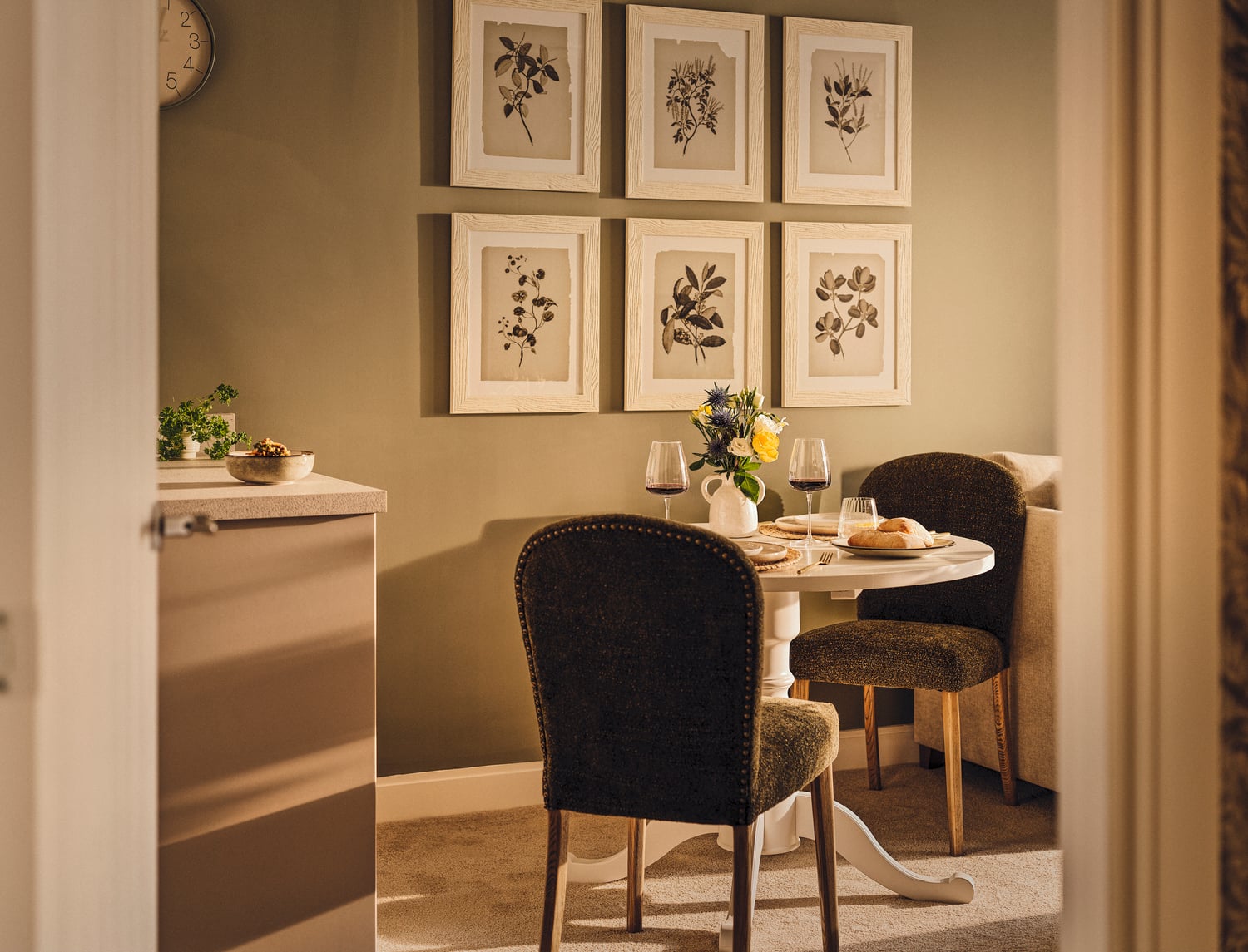 a dining table with chairs and a vase of flowers
