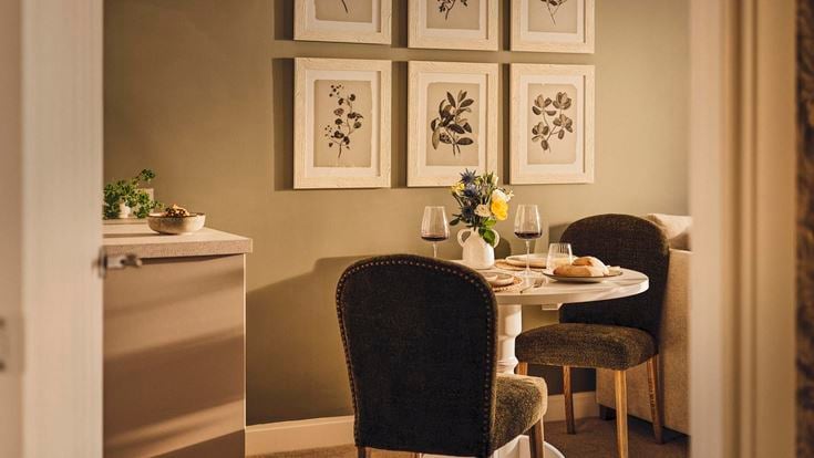a dining table with chairs and a vase of flowers