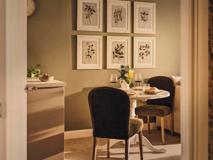 a dining table with chairs and a vase of flowers