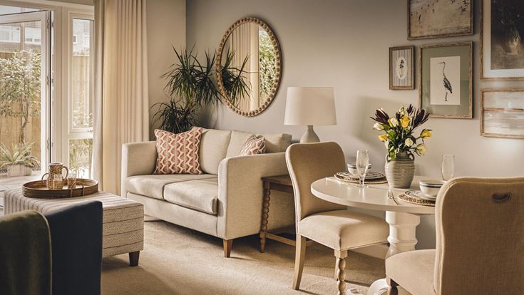 a living room with a round mirror