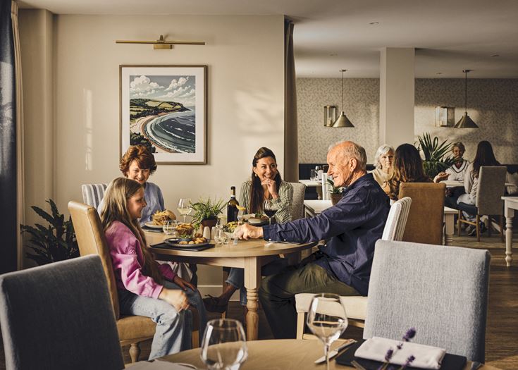 A retired couple enjoy a meal with their family in their retirement development.