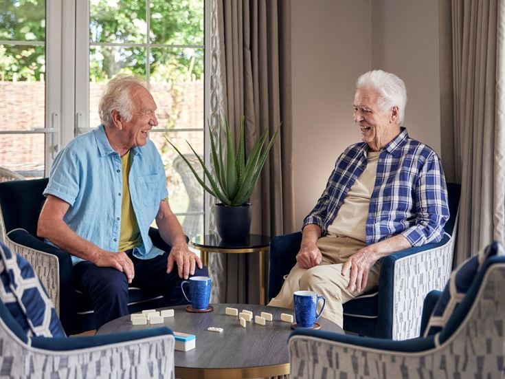 a couple of men sitting at a table with coffee cups