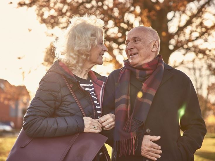 a man and woman standing next to each other and looking at each other