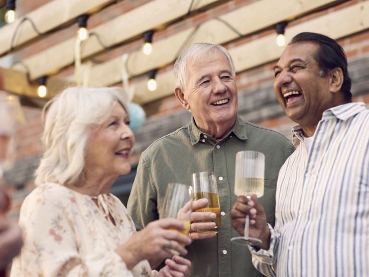 a few people laughing and drinking wine