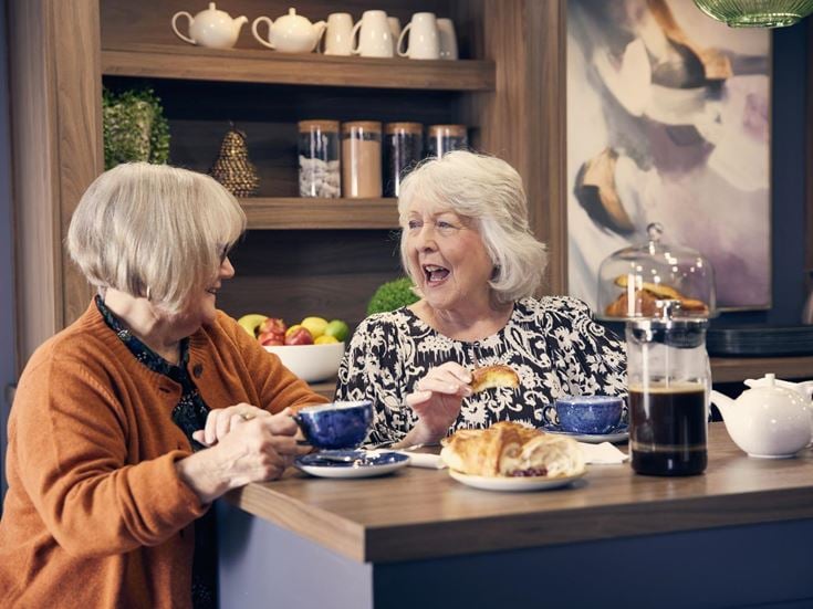 a person and an old woman eating at a table