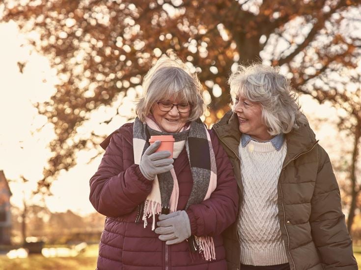 a couple of women standing next to each other and smiling