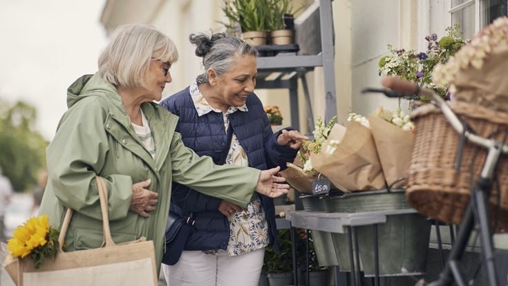 a couple of women looking at a phone