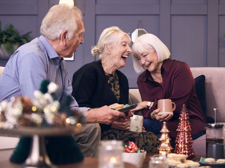 a group of people sitting at a table with food and drinks