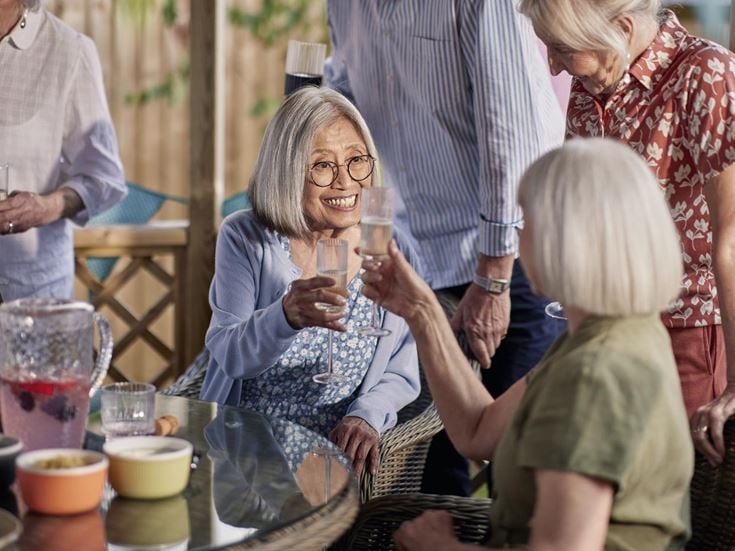 a group of people standing around a table with wine glasses