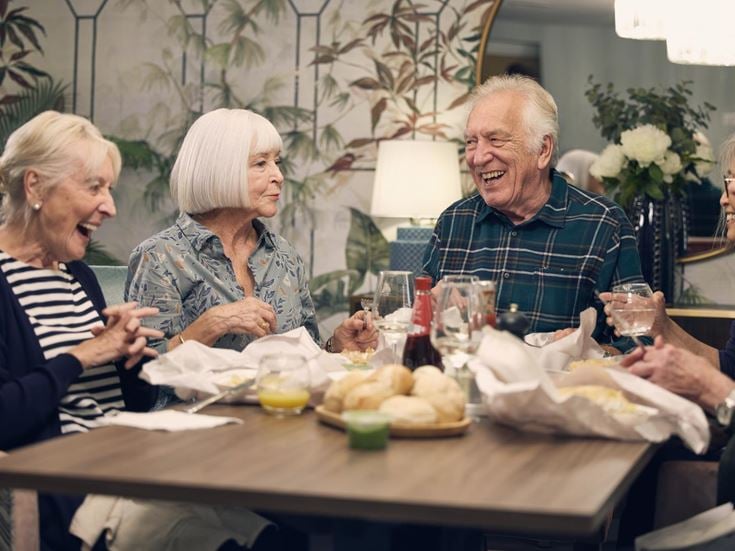 a group of people sitting around a table with food