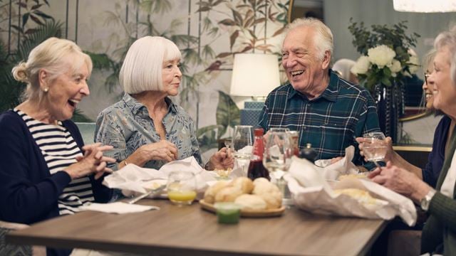 a group of people sitting around a table with food