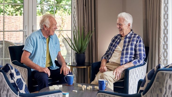 a couple of men sitting at a table with coffee cups
