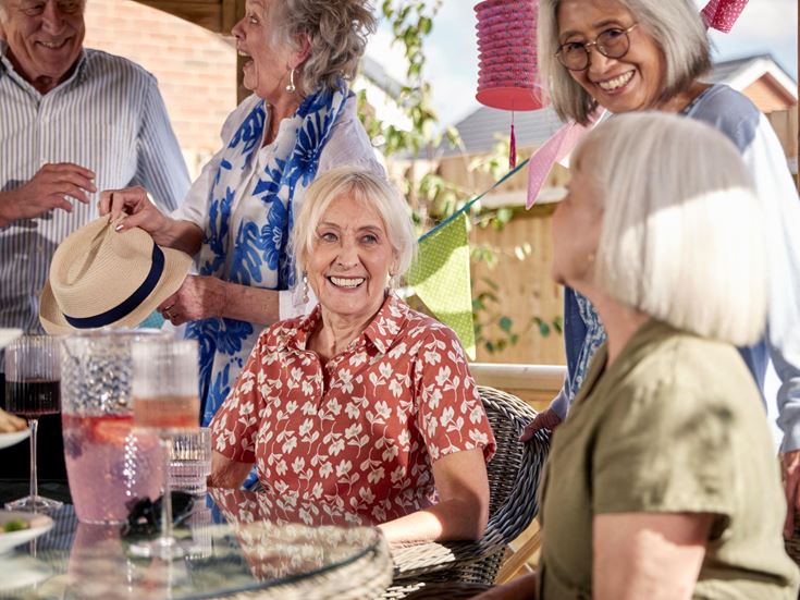 a group of people standing around a table with food