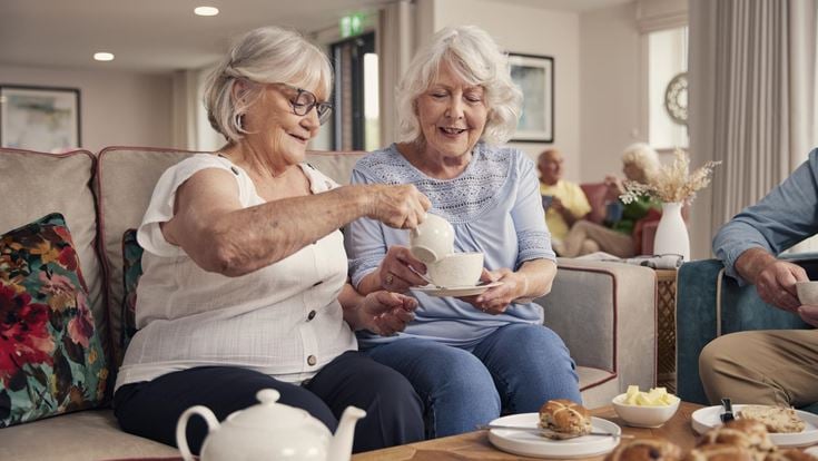 a couple of women sitting on a couch and eating