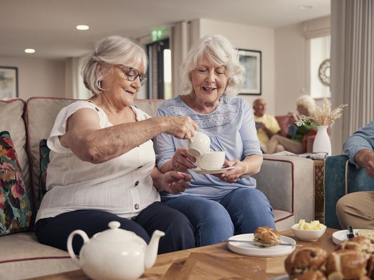 a couple of women sitting on a couch and eating