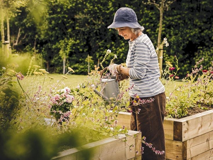 a man holding a bucket of flowers