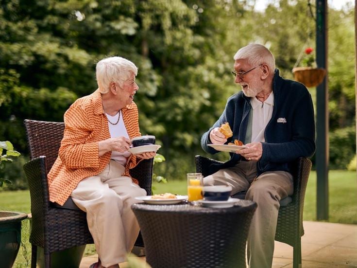 a man and woman sitting at a table eating food