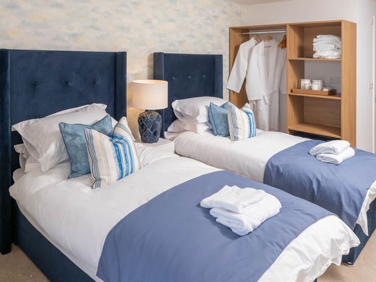 a couple of beds with blue sheets