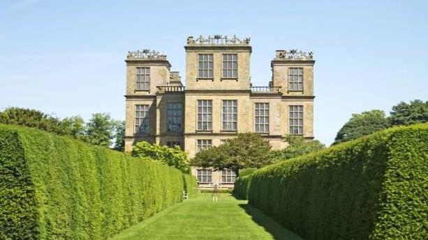 a large building with a green lawn with Hardwick Hall in the background