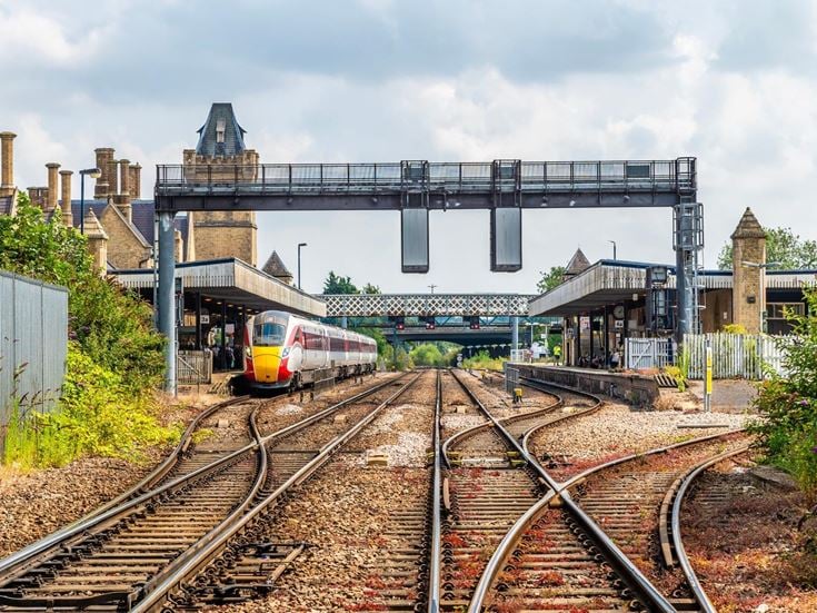 A view along the train tracks towards Lincoln railway station with a train next to one of the platforms.