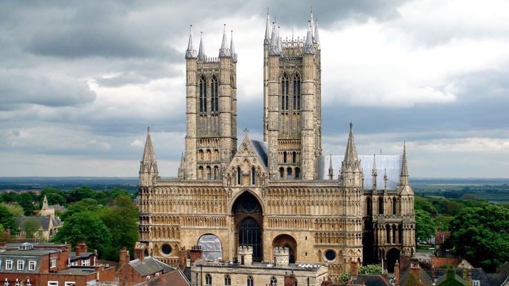 Lincoln Cathedral, with two Gothic towers and a stormy sky.